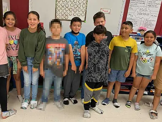 Elsa Avila’s students pose for a picture in their newspaper shoes moments before the shooter entered their school. Children’s faces are shown with parental consent. Credit: Courtesy of Elsa Avila, pixelated by ProPublica, The Texas Tribune, and FRONTLINE