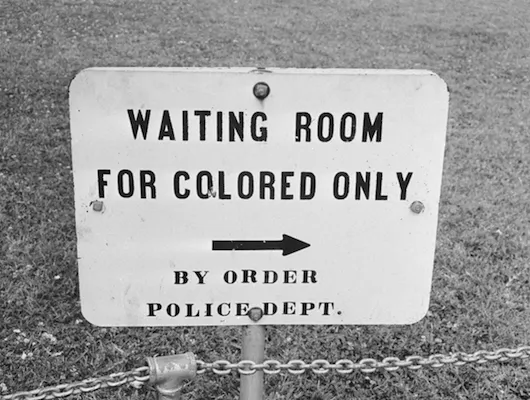 photo of sign pointing to "waiting room for colored only"
