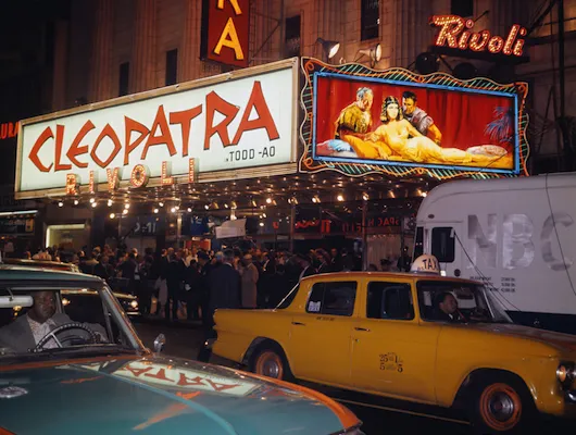 Photo of street scene with crowd outside Rivoli Theatre showing Cleopatra