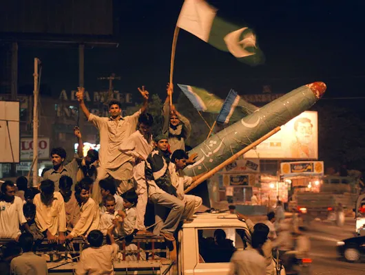 Men in Pakistan gathered on the back of a pickup truck