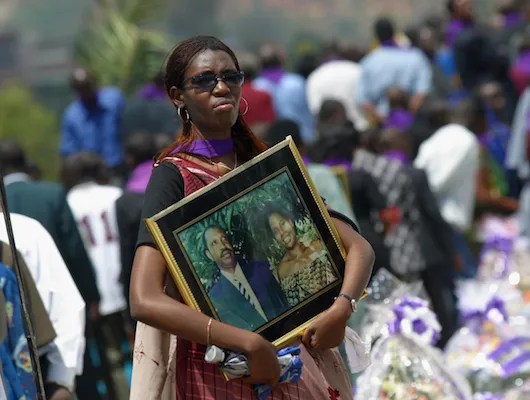 woman holding photograph of murdered loved ones