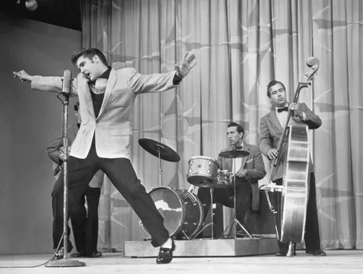 B&W photo of Elvis performing on stage