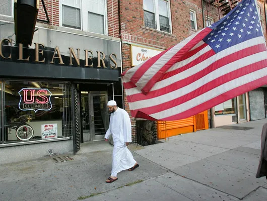 Photo of muslim man walking on sidewalk in New York City.