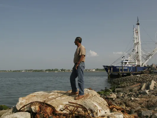 Man standing on shore looking out to sea